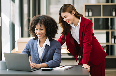 Two smiling women looking at laptop