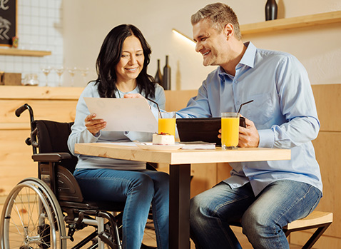Man and Woman in a wheelchair working together in a cafe