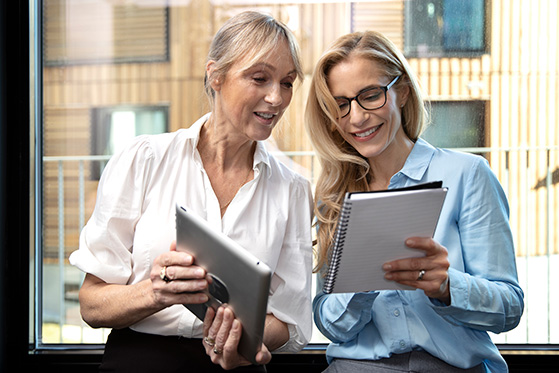 Two women looking at notepads