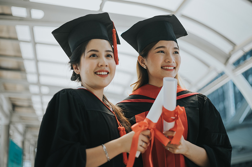 Two smiling women at their graduation ceremony