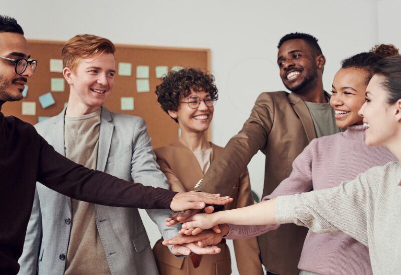 diverse workers looking happy with their hands in front