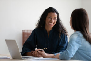 two women talking at a desk